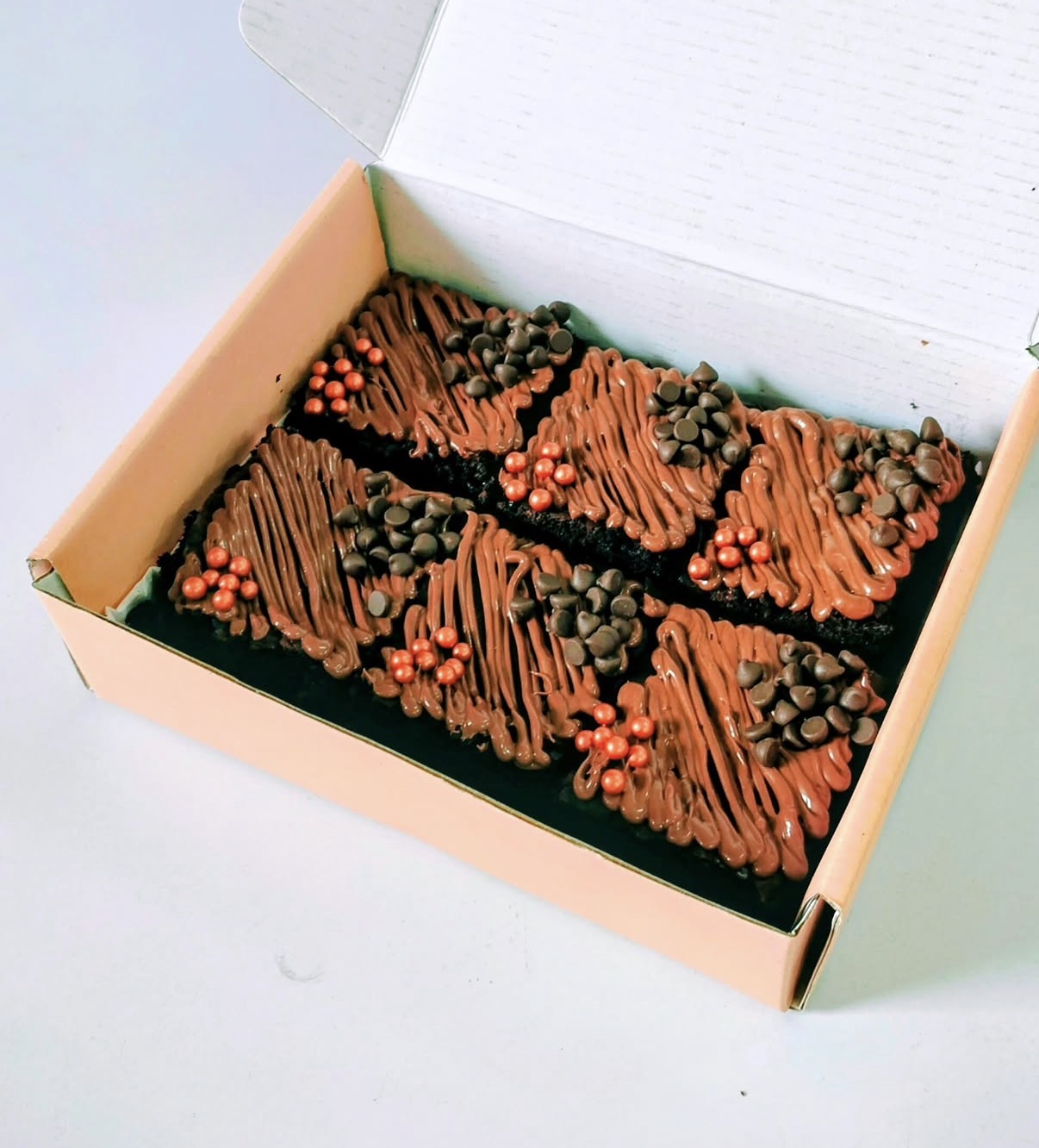 Nutella drizzled brownies in a pink box