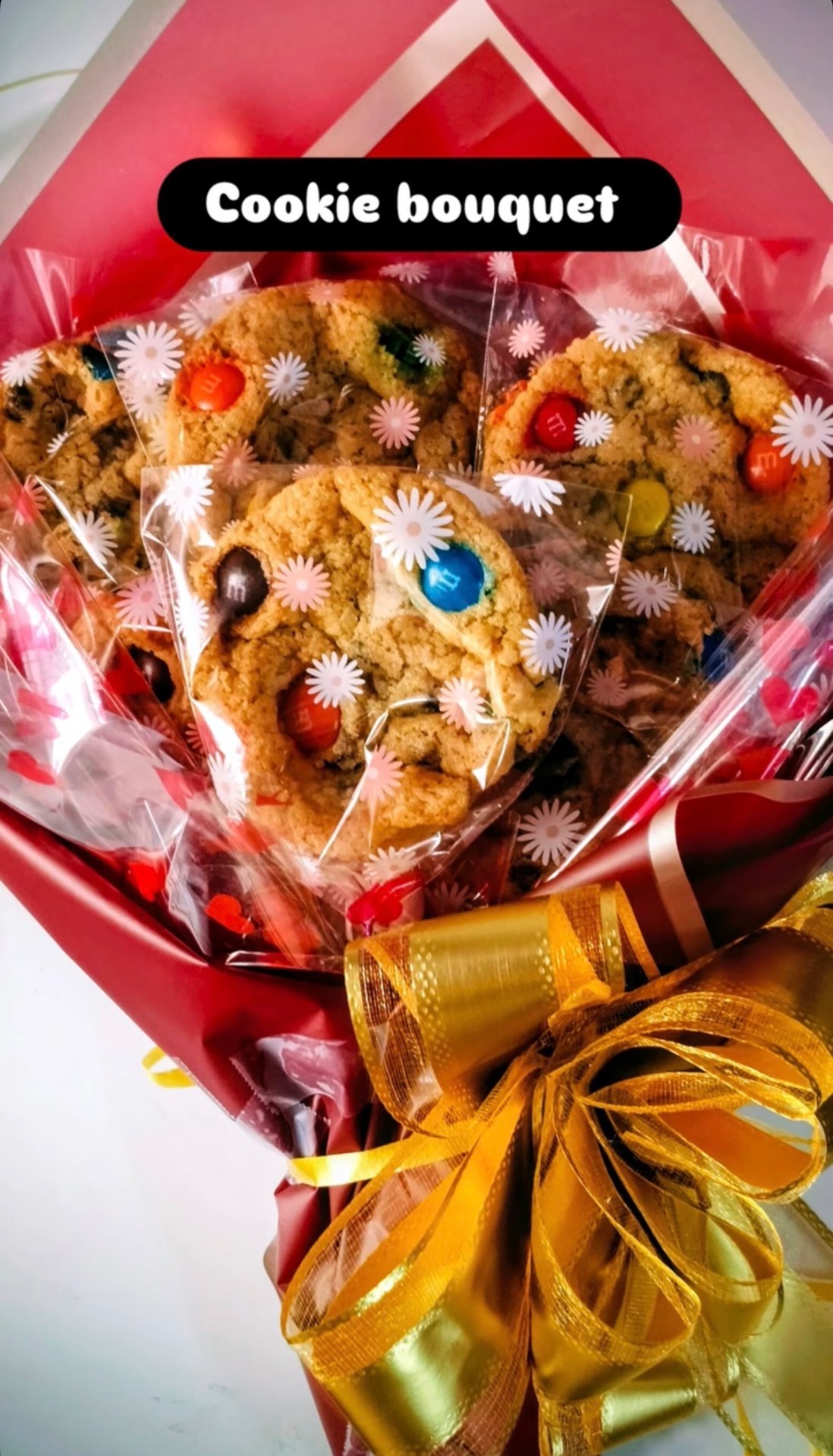 Cookie bouquet wrapped in red paper with a gold bow